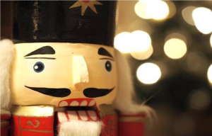 Close up of a nutcracker with blurred holiday lights in the background