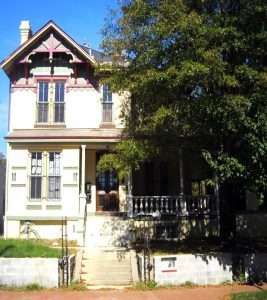 Photograph f a house with a tree to its left