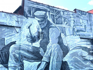 A man chiseling; mural in Eckington, Washington, D.C. Photo by Briana Pocratsky.